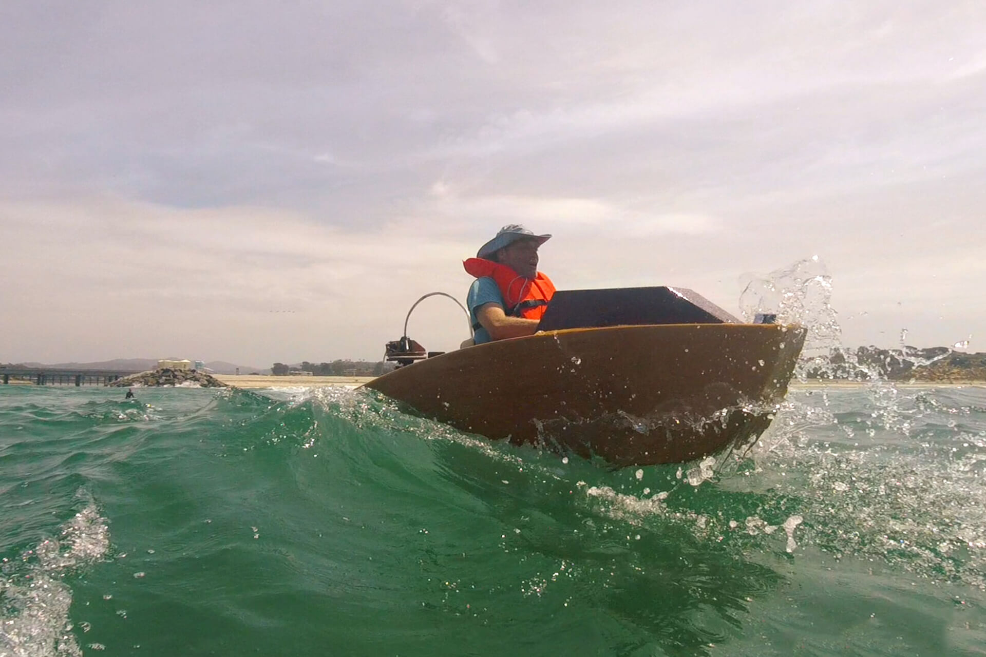Carl jumping an ocean wave in his mini boat