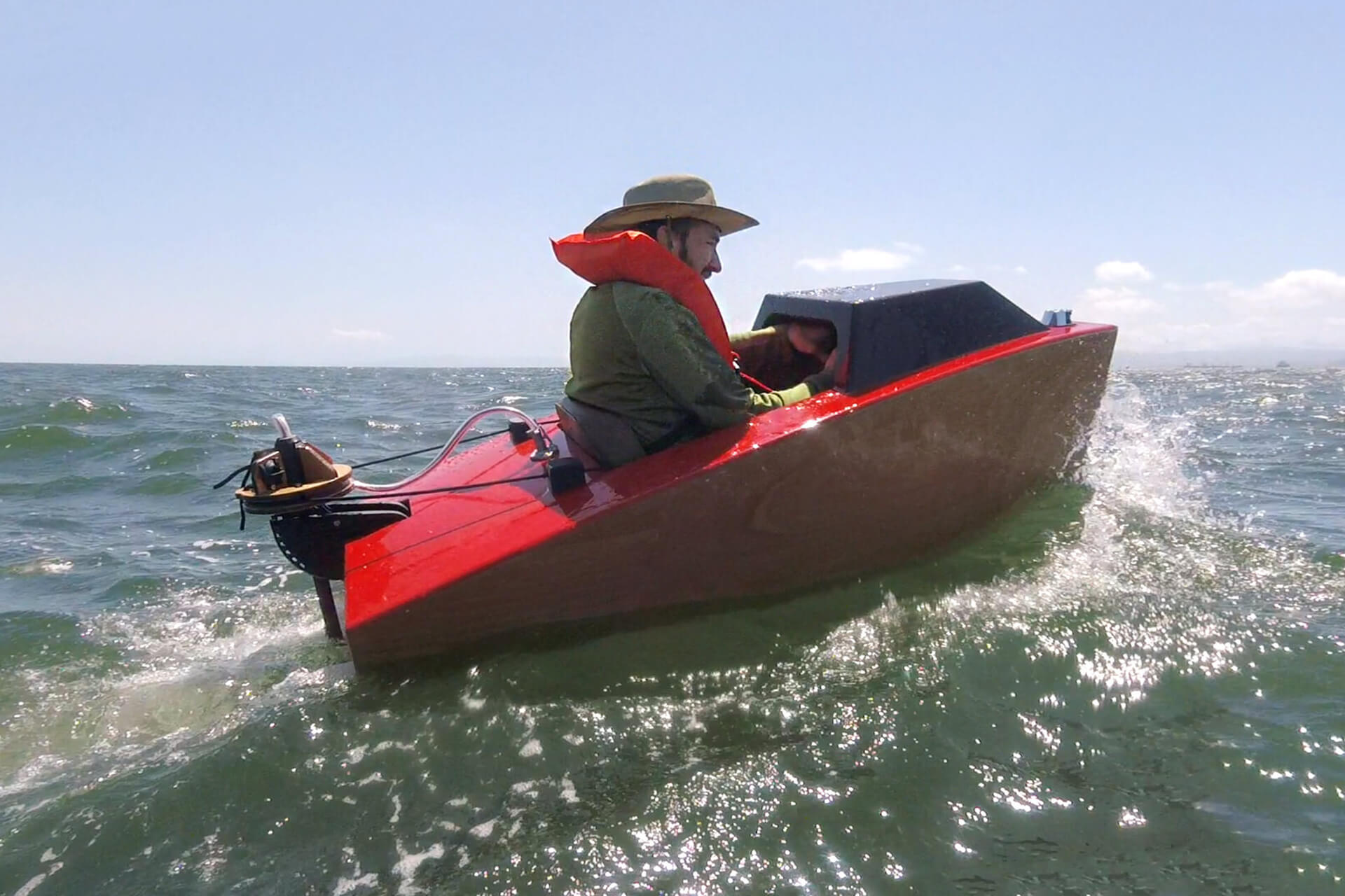 Josh riding in choppy ocean water in his mini boat