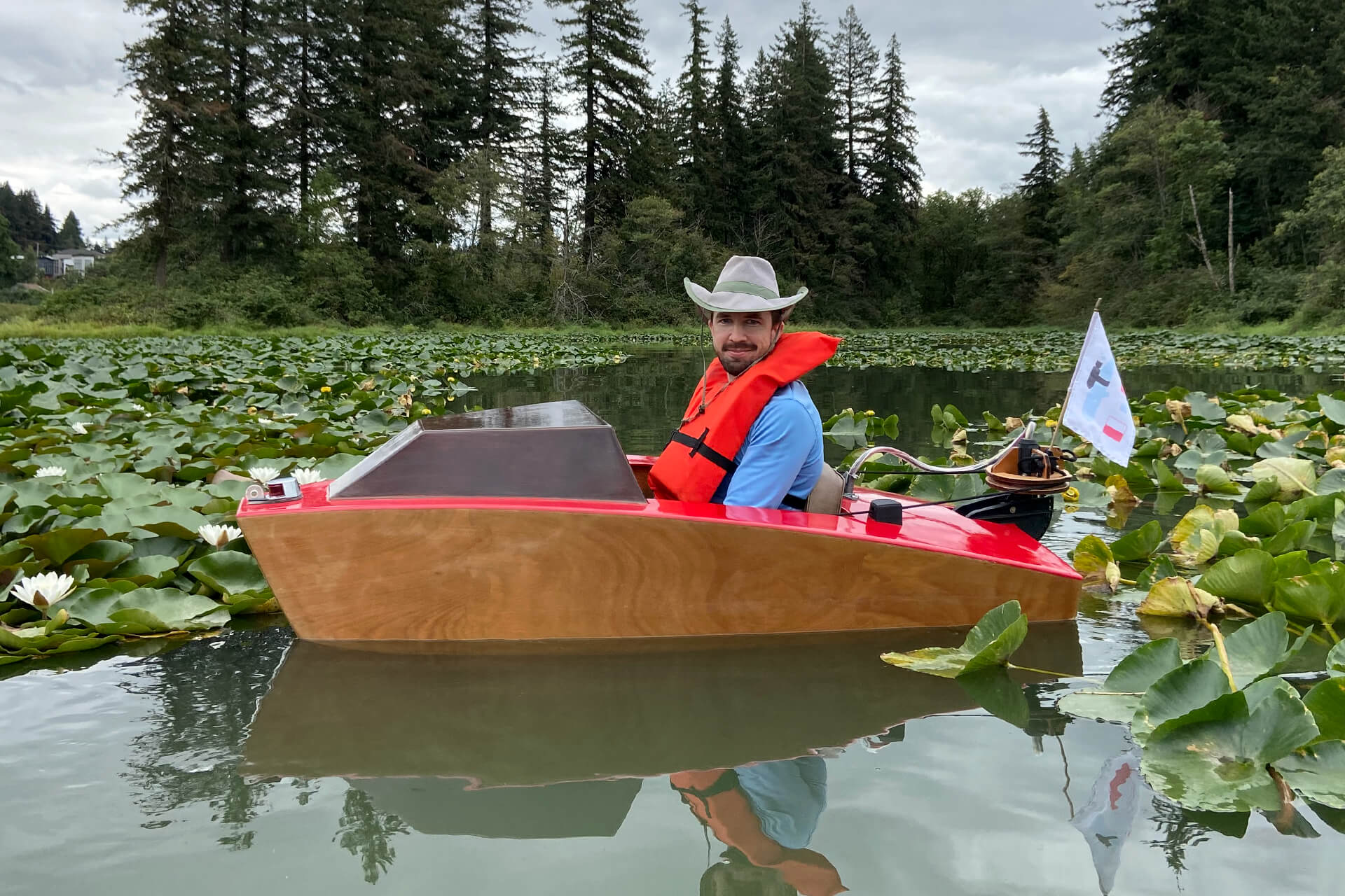 The mini boat floating in Lacamas lake, surrounded by lilly pads