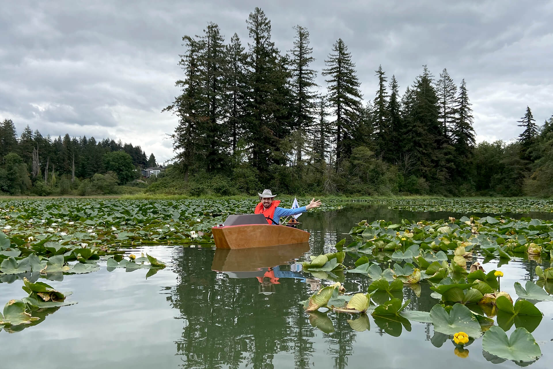 A mini boat in the middle of a large lilly pad forest
